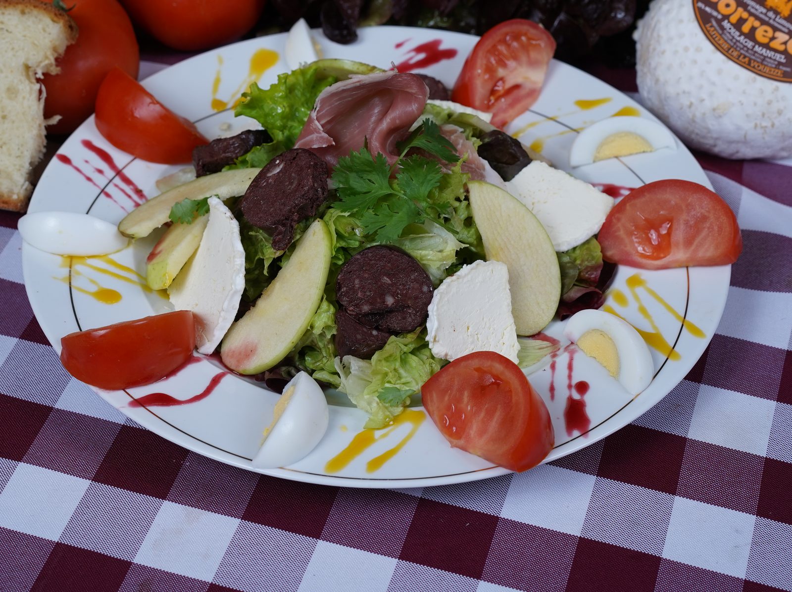 Une salade composée, avec des crudités, du fromage et du pain de campagne