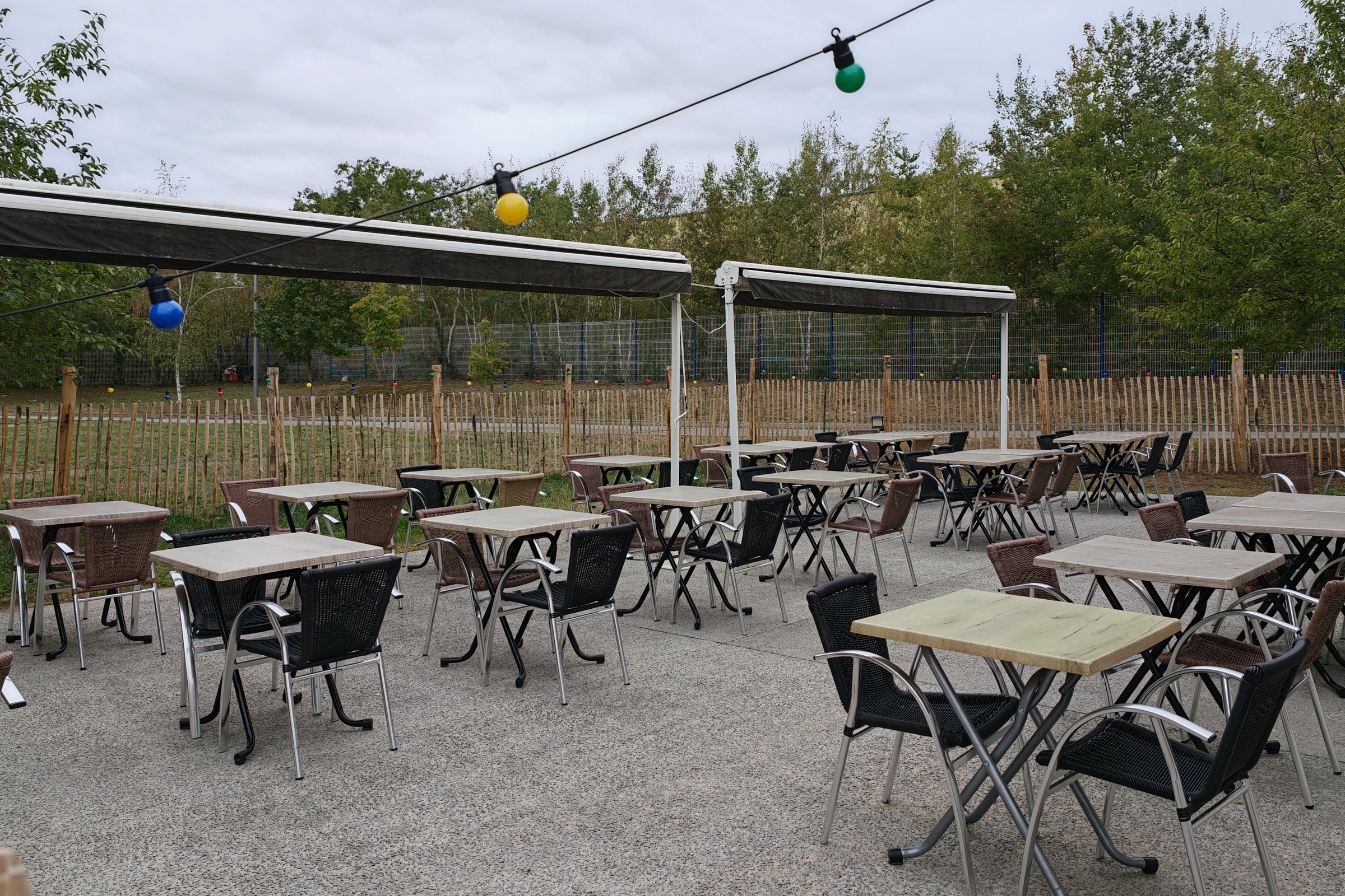 La terrasse du restaurant, ses tables et ses stores