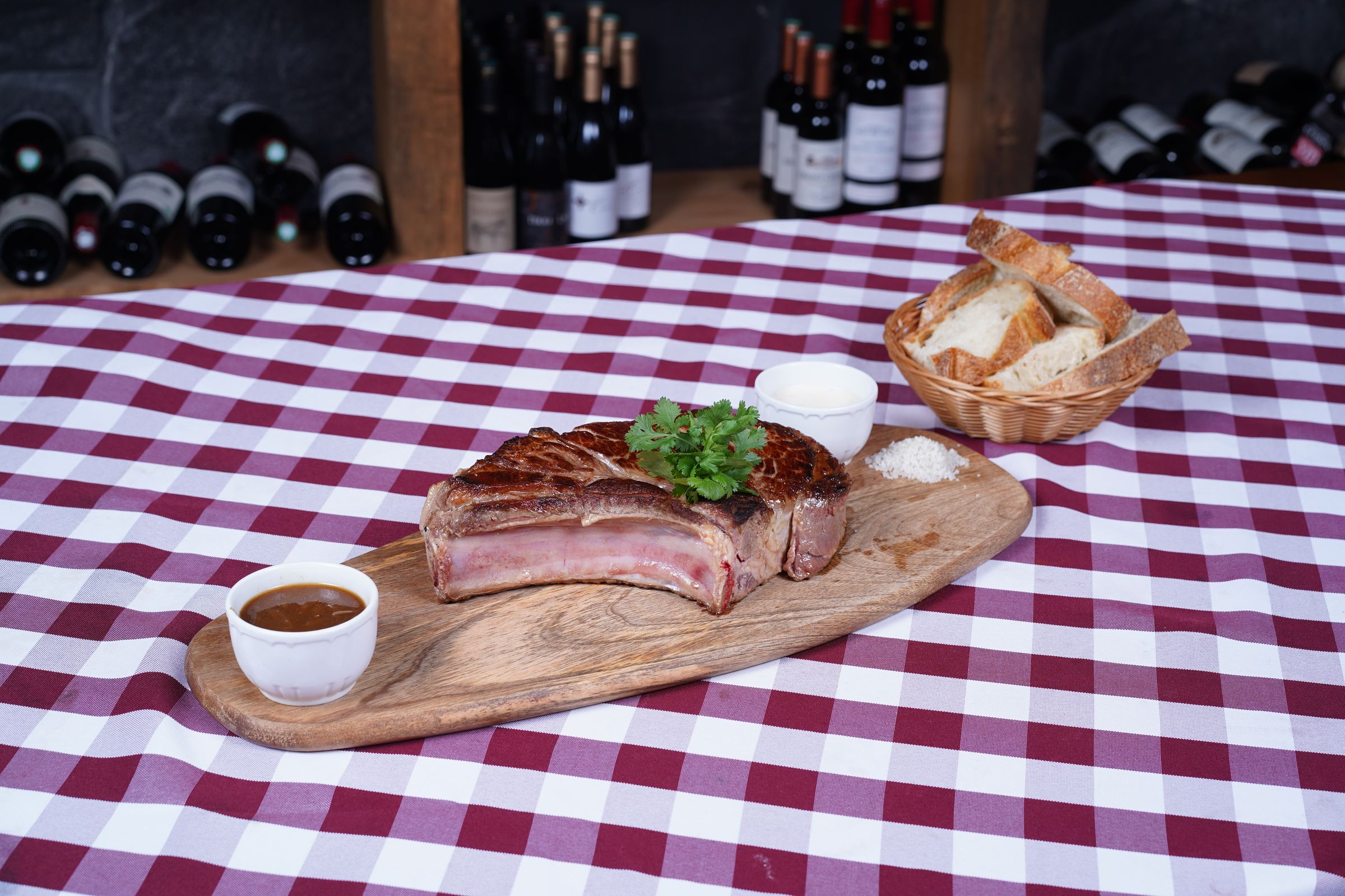 Une côte de bœuf de race limousine sur sa planche, avec du pain et une sauce maison