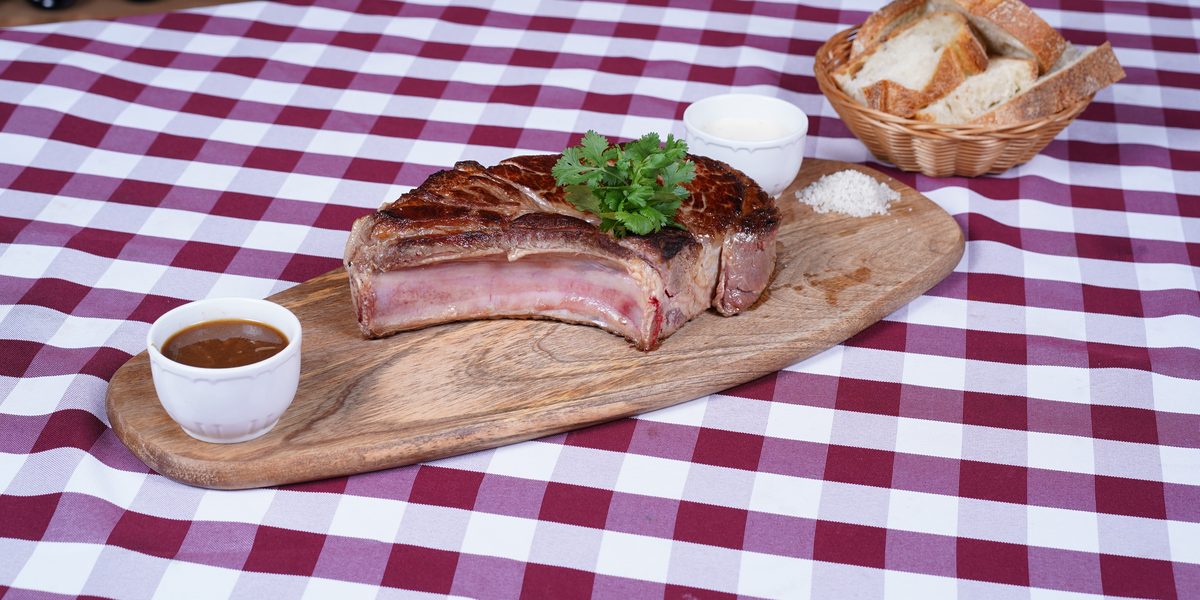 Une côte de bœuf de race limousine sur sa planche, avec du pain et une sauce maison, Au Paysan Gourmand à Limoges