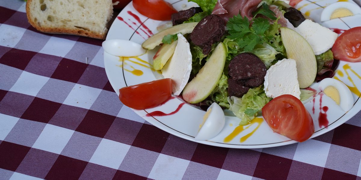 Une salade composée du restaurant : crudités, œuf dur, fromage et charcuterie sur un lit de salade verte