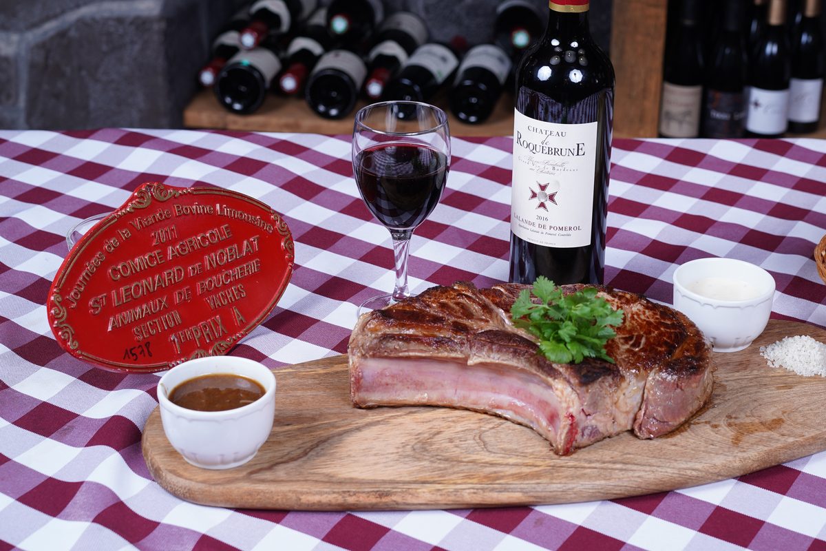 Une côte de bœuf limousine sur sa planche, à côté d'une plaque rouge des Journées de la viande bovine limousine 2011