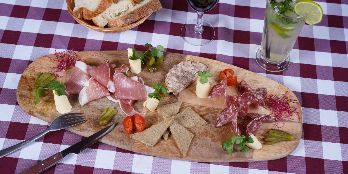Une planche à partager du restaurant : charcuteries, pâté, fromage, cornichons et pain de campagne