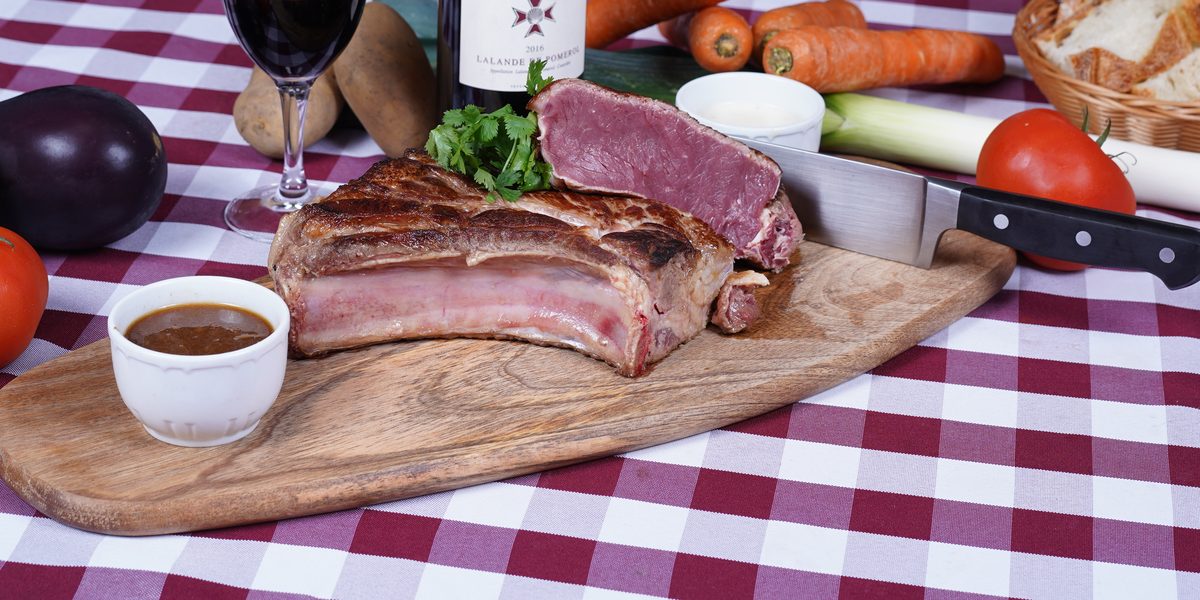 Une pièce de bœuf limousin persillée, posée sur une planche de bois au restaurant Au Paysan Gourmand