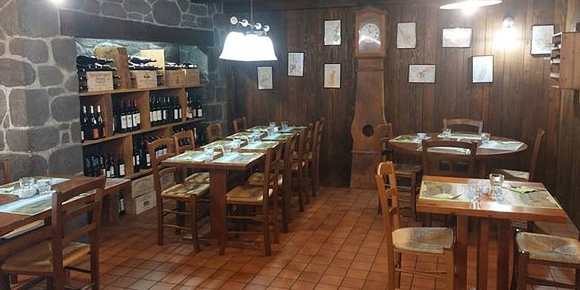 Une salle de plain-pied du restaurant Au Paysan Gourmand, à Limoges : sol carrelé, tables en bois et chaises paillées