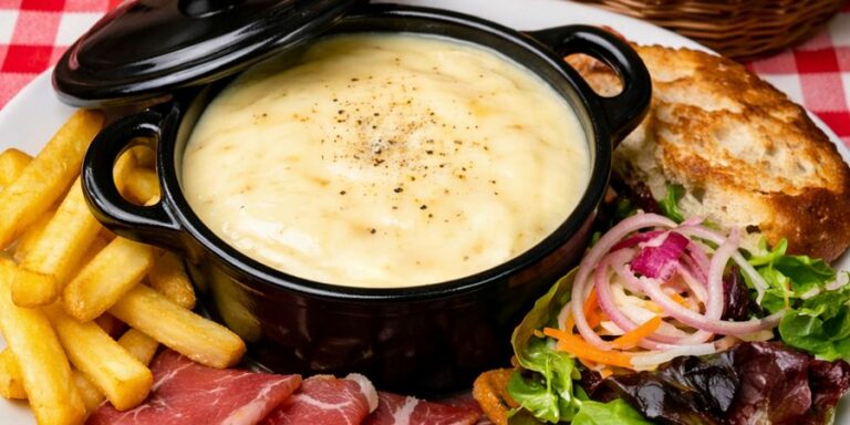 Le fondu creusois dans sa cocotte, avec des frites, de la charcuterie, une salade et du pain grillé
