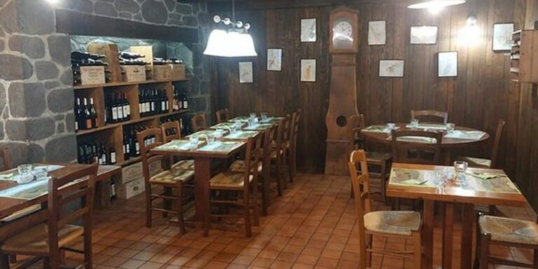 Une salle de plain-pied du restaurant Au Paysan Gourmand, à Limoges : sol carrelé, tables en bois et chaises paillées